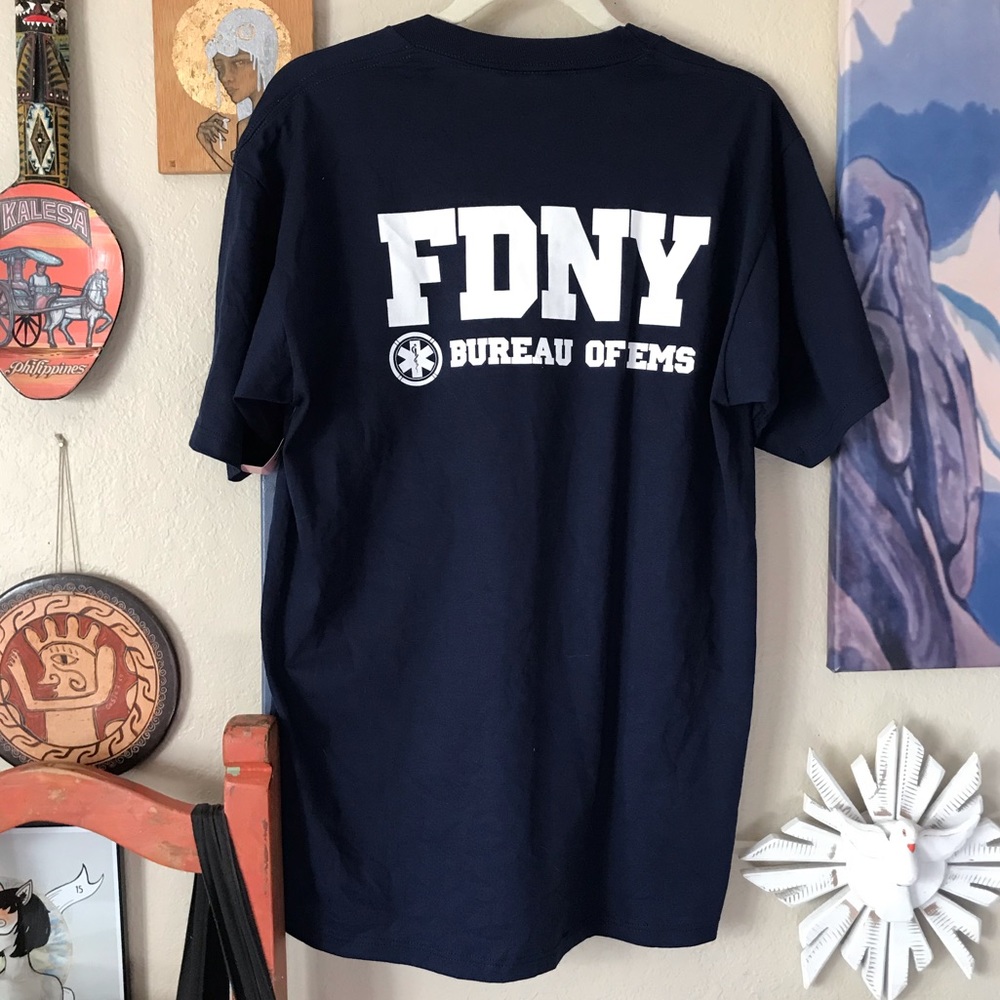 FDNY DEADSTOCK VINTAGE 90s SOUVENIR TSHIRT IN NAVY WITH FDNY BADGE ON CHEST.